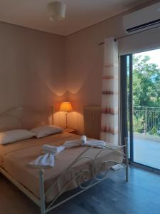 een slaapkamer met een bed en een glazen schuifdeur bij KAMARI APARTMENTS in Verga Kalamata