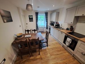 a kitchen and dining room with a table and chairs at Clematis Cottage, Fortrose in Fortrose