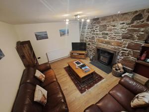 a living room with a couch and a fireplace at Clematis Cottage, Fortrose in Fortrose
