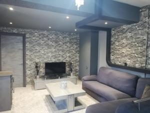 a living room with a couch and a tv at EnjoyRhodes Villa near Faliraki in Kalithies