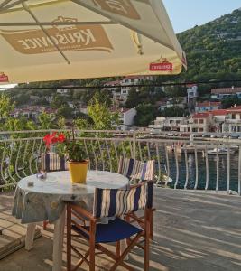 a table and chairs under an umbrella on a balcony at Apartments Jakov in Starigrad