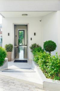 una entrada a un edificio blanco con plantas en Summer In en Polykhrono