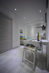 a white dining room with a white table and chairs at La Casetta del Ronco1 Ortigia in Siracusa