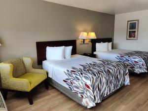 a hotel room with two beds and a chair at Red Roof Inn Houston - Jersey Village in Houston