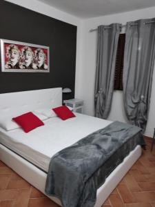 um quarto com uma grande cama branca com almofadas vermelhas em Appartamento Martina em Codaruina
