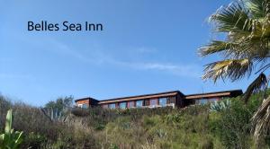 uma casa sobre uma colina com as palavras sinos do mar pousada em Belles Sea Inn em Port Aransas