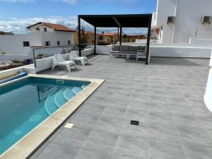 un patio con piscina, mesa y sillas en Villa Neila, Fuerteventura en Tarajalejo