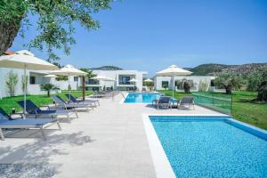 a pool with chairs and umbrellas next to a resort at Encanto Village -Apartments in Potos