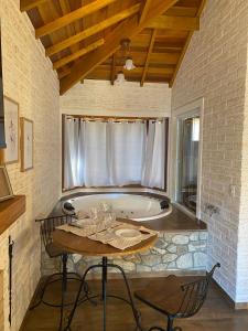 a bath tub in a room with a table and a table sidx sidx at Chale Villa do Valle in Monte Verde
