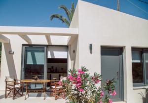 a villa with a table and chairs on a patio at Andromahi Apartments & Suite in Laganas
