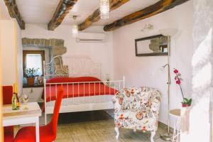 a bedroom with a red bed and a chair at Apartman studio Baladur in Roč