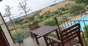 a wooden table and two chairs on a balcony at Il Giardino delle Erbe in Badia