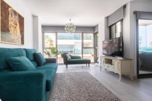 a living room with a blue couch and a tv at Reinapart Patacona Beach 46 in Valencia