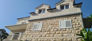 a brick building with white windows on it at APARTMAN BRIGIT - CENTAR in Bol