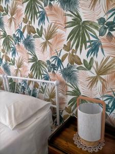 サン・ヴィート・ロ・カーポにあるCasa Ciclaminoのベッドルーム1室(トロピカルな壁紙のベッド1台付)