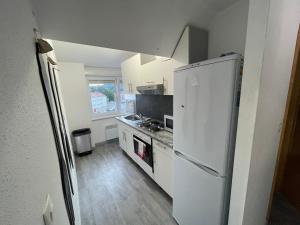 ベルフォールにあるBelfort Appartement confortのキッチン(白い冷蔵庫、コンロ付)