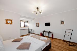 Habitación blanca con cama y TV en Wood&Steel Apartment, en Galaţi