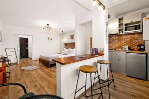 a kitchen and living room with a bed in the background at Wood&Steel Apartment in Galaţi