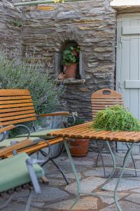 two benches and a table with plants on a patio at Victoria's Summerhouse in Andros +18 photos