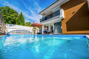 a swimming pool in front of a house at MF Diamond Bay Apartment in Siófok