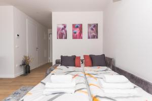 ein großes Bett in einem Wohnzimmer mit Gemälden an der Wand in der Unterkunft Luxury Adria SEA & CITY View apartment in Makarska