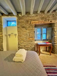 a bedroom with a bed and a table in a room at The Walnut Tree - Cycladic Getaway with Sea Views in Lámira