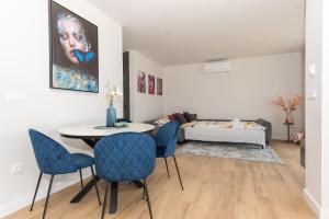 ein Wohnzimmer mit einem Tisch, Stühlen und einem Sofa in der Unterkunft Luxury Adria SEA & CITY View apartment in Makarska
