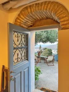 een open deur met uitzicht op een patio bij The Walnut Tree - Cycladic Getaway with Sea Views in Lámira