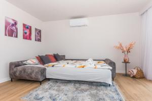 ein Schlafzimmer mit einem Bett und einem Sofa in der Unterkunft Luxury Adria SEA & CITY View apartment in Makarska