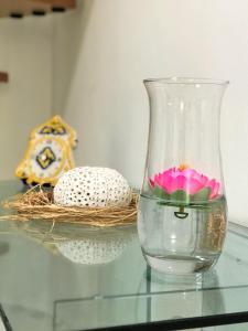 a glass vase sitting on a glass table with a flower in it at Vecchia Paradiso - A un passo dal Mare in Messina