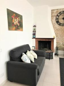 a living room with a black couch and a fireplace at Vecchia Paradiso - A un passo dal Mare in Messina