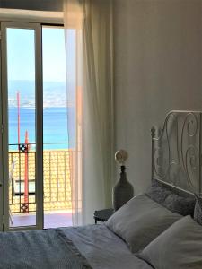 a bedroom with a bed and a view of the ocean at Vecchia Paradiso - A un passo dal Mare in Messina