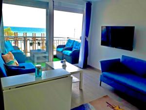 a living room with blue furniture and a view of the ocean at SUN SEA No 3 in Perea