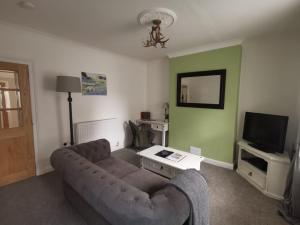 a living room with a couch and a tv at Welcoming 2 bedroom home with large outdoor space in Aspatria