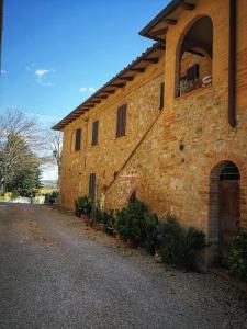 un edificio de ladrillo con plantas a su lado en CASA VACANZE CLAUDIA- 10 min da Siena, en Malignano
