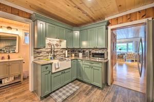 a kitchen with green cabinets and a wooden floor at Lakefront Battle Creek Home with Fishing Dock! in Battle Creek