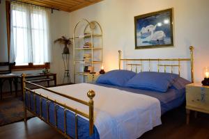 a bedroom with a bed with blue pillows at Renovated Old Manor House With Yard in Arnaia