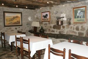 uma sala de jantar com duas mesas e pinturas na parede em Can Pei em Oix