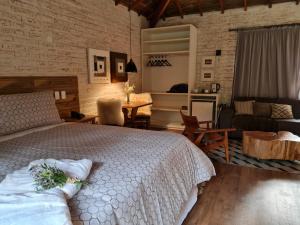 um quarto com uma cama e uma sala de estar em Pousada Toca Da Coruja em Monte Verde