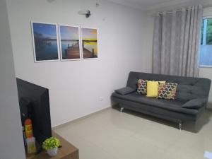 a living room with a couch and a television at Condomínio Vila da Praia em São José - Maragogi in São José da Coroa Grande