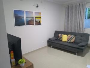 a living room with a couch and a television at Casa Temporada - São Jose in São José da Coroa Grande
