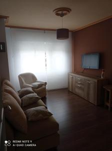 sala de estar con sofá y TV de pantalla plana en Piso centrico en Pravia, con 3 habitaciones sin ascensor, en Pravia