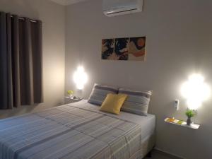 a bedroom with a bed with two lights on at Casa Temporada - São Jose in São José da Coroa Grande