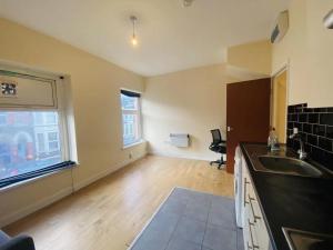 an empty kitchen with a sink and a window at Cardiff simple and humble spacious 1-bed flat 1 mile to City Centre with basic furniture in Cardiff
