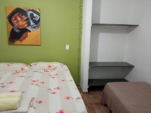 a bedroom with a bed and a picture on the wall at Hospedaria Vila Else in Vila Velha