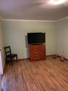 sala de estar con TV de pantalla plana y tocador de madera en CASA VILLA AZUL 3 PISOS, en Antofagasta