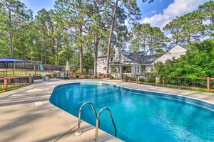 a swimming pool in front of a house at Peaceful Southern Pines Home with Pool and Yard! in Southern Pines