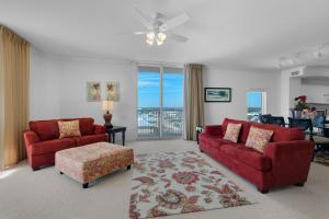 a living room with two red couches and a table at Tidewater 901 in Panama City Beach