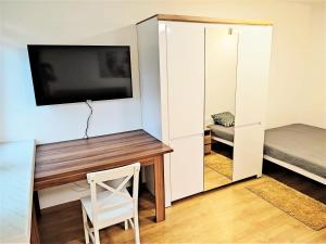 Habitación con escritorio, TV y espejo. en Zwierzyniecka Apartamenty LUNA Białystok, en Białystok