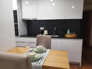 uma cozinha com uma mesa com pratos e copos de vinho em PIMENTA FOUR HOUSE em Amarante